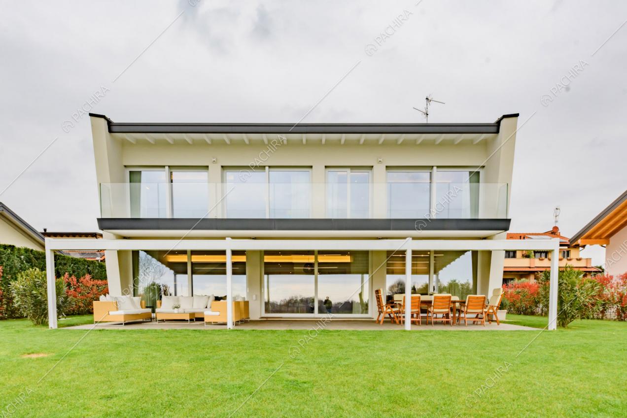 Dal giardino vista sulla villa con terrazza, veranda e grandi vetrate