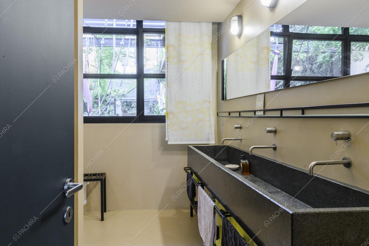 Bagno moderno con pareti bianche e finestra dalle rifiniture nere