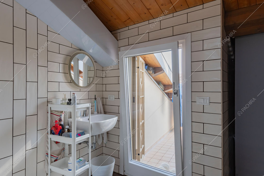 Bagno con travi in legno a vista sul soffitto della villa Matico, location in stile contemporaneo a Roma