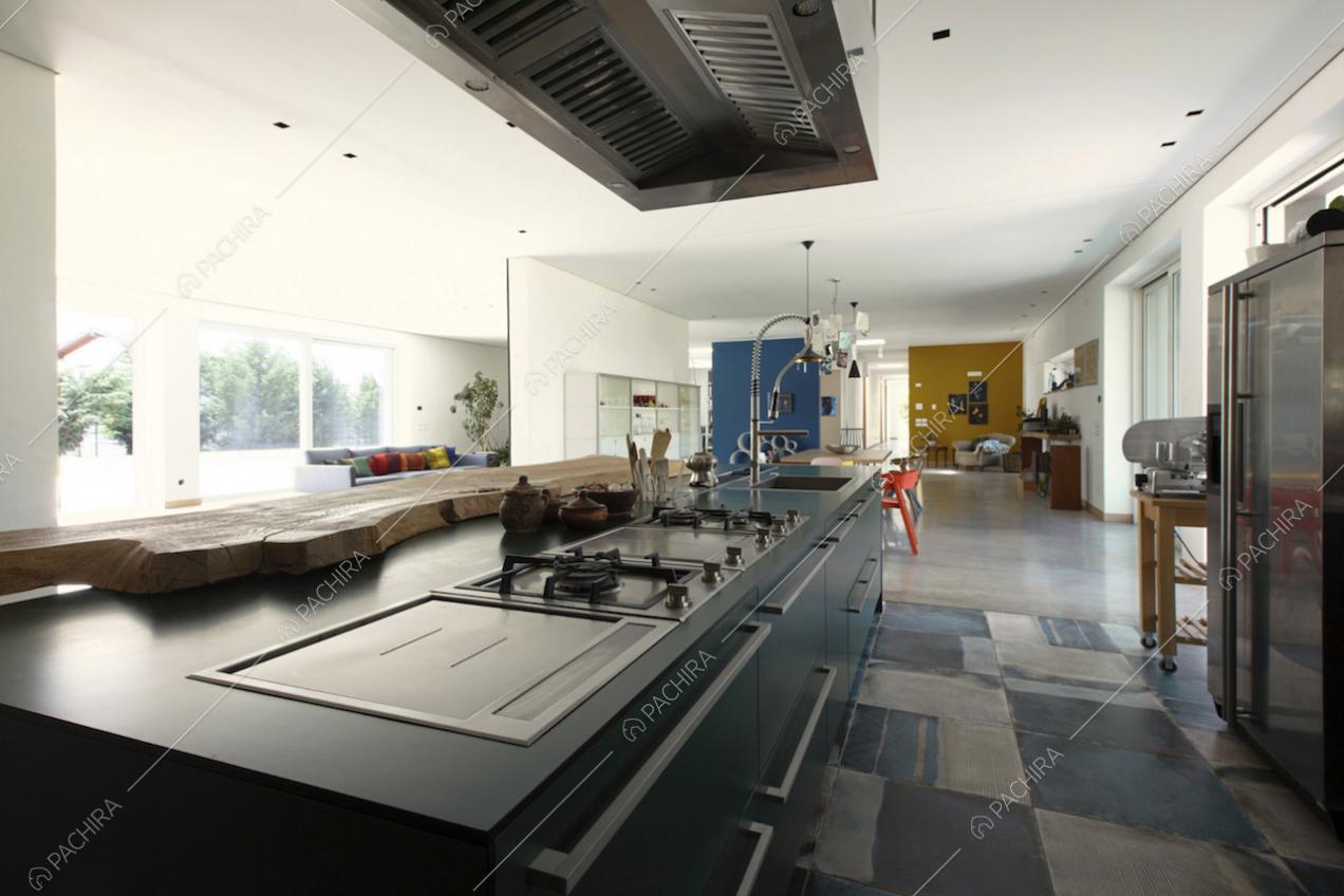 Piano cottura e frigorifero metallizzato nella cucina a vista