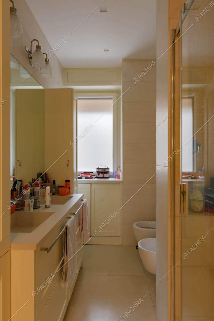 Bagno con box doccia e pavimento bianco