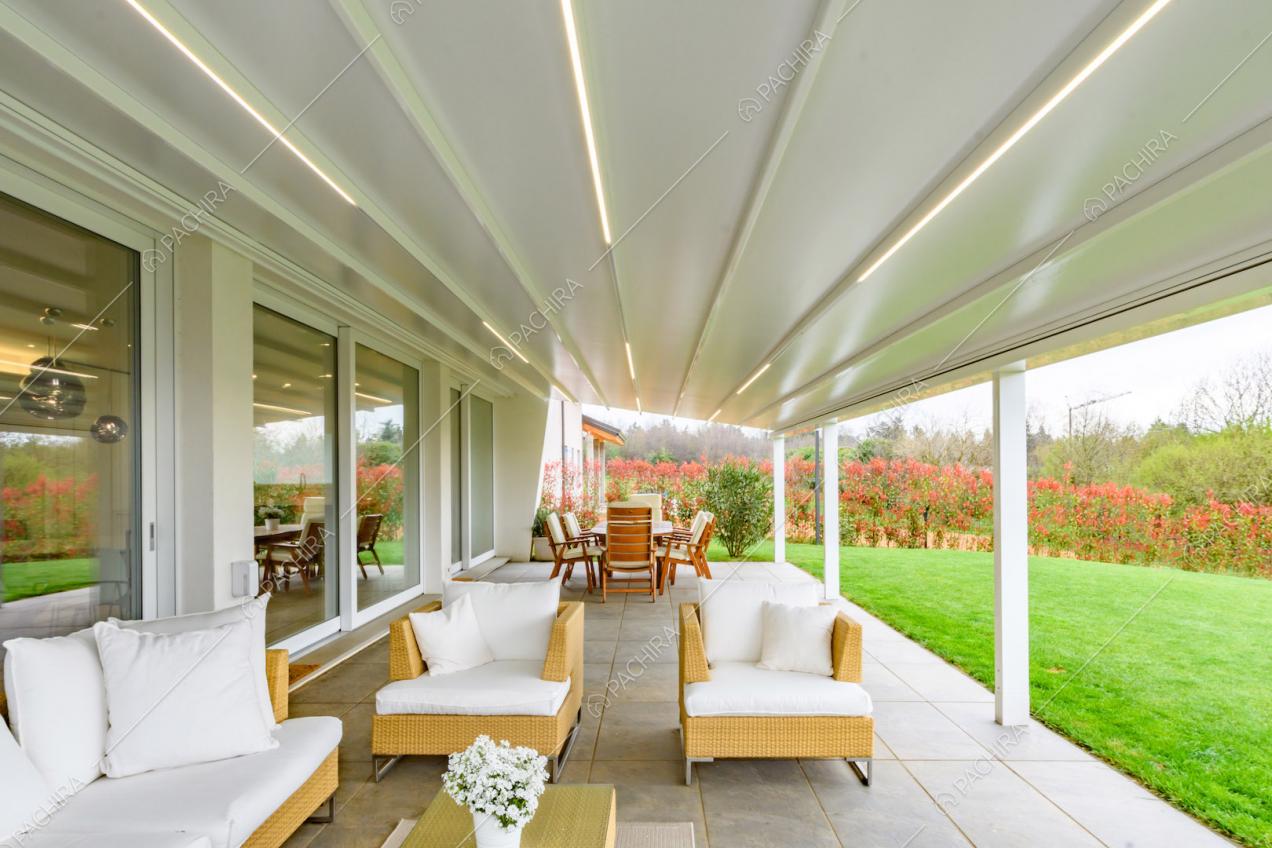 Grande veranda con salotto da esterni, tavolo da pranzo e vista sul giardino