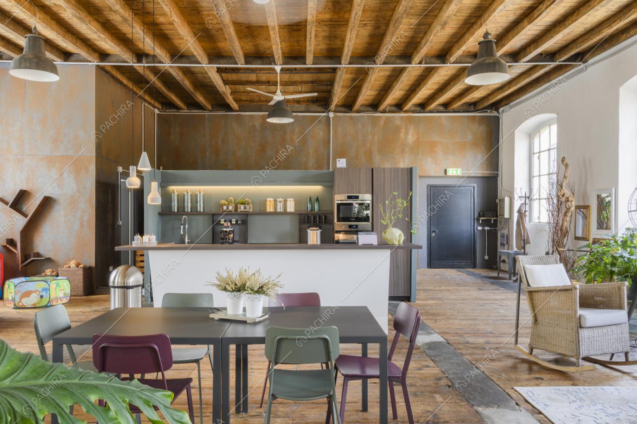 Open space con cucina a vista e tavolo con sedie
