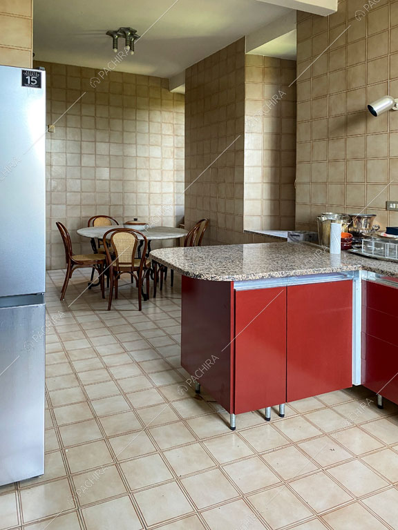 Cucina rossa con piastrelle beige su pavimento e pareti