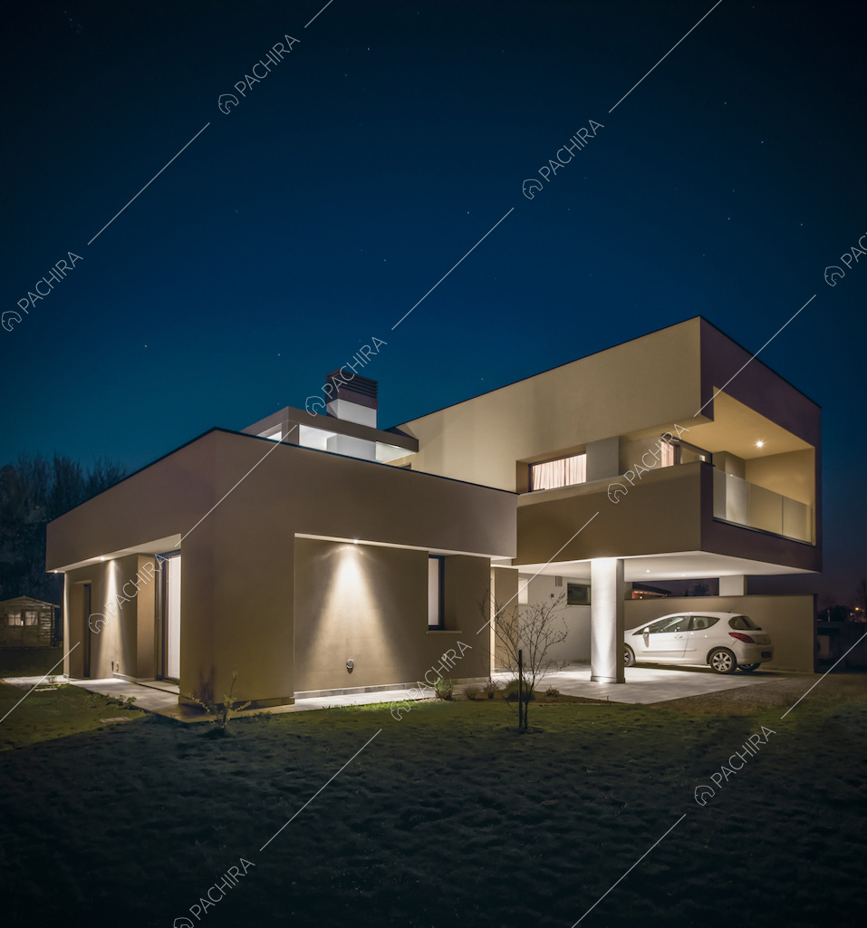 Vista notturna degli esterni della villa con veranda che funge da garage 