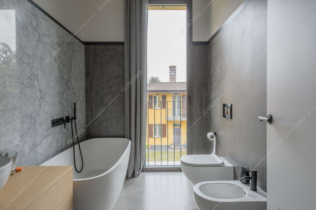 Bagno con vasca e parete in marmo dell'appartamento Fiore di porro, location in stile minimal a Monza