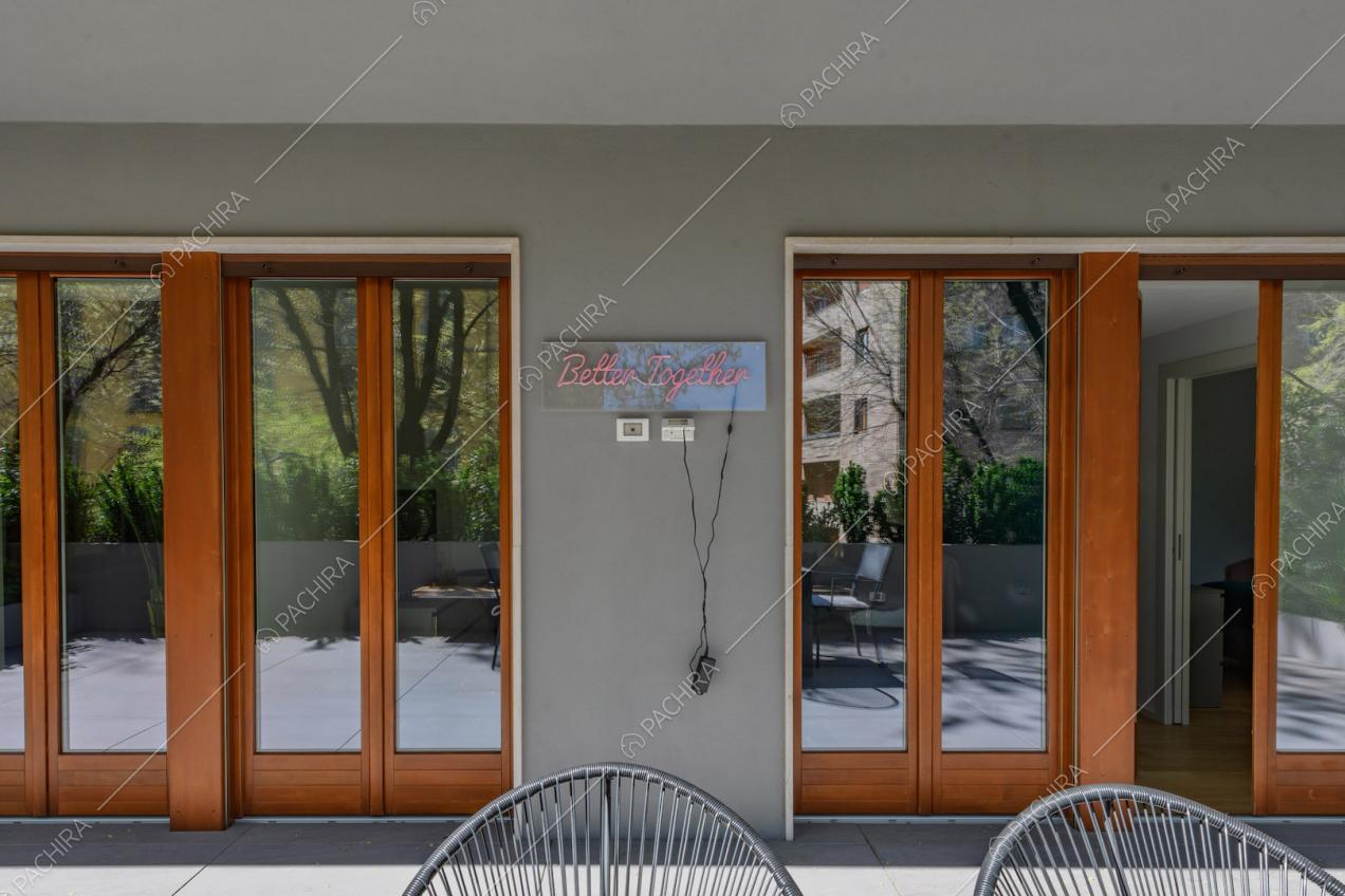 Vista sulle porte-finestre con infissi marroni in legno dalla terrazza