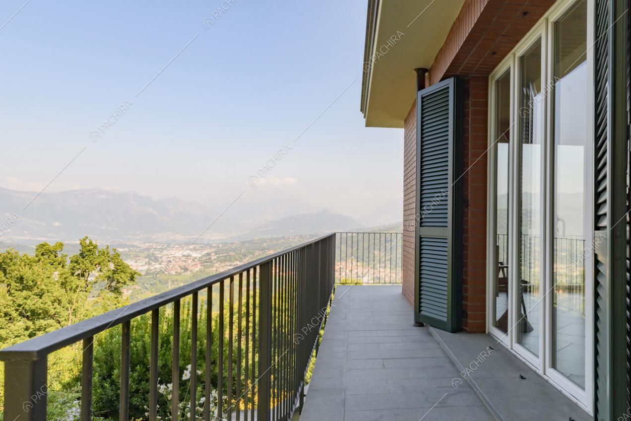 Balcone con ringhiera, porte-finestre e vista panoramica sulle montagne