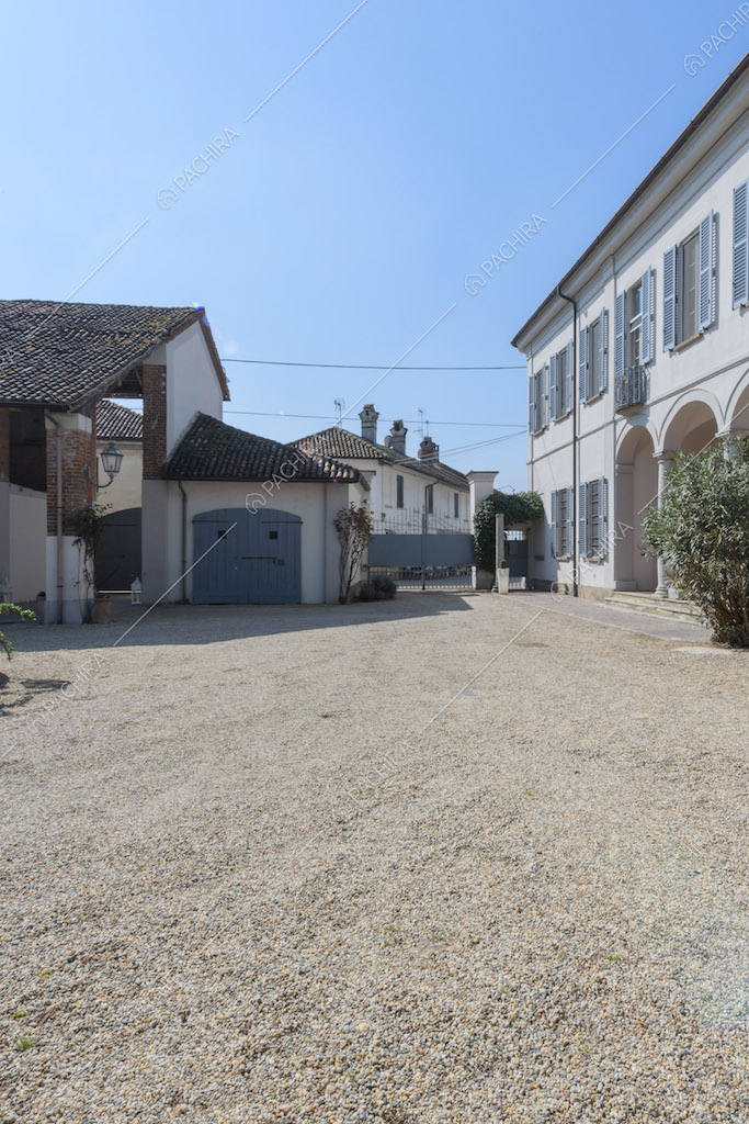 Pavimentazione in ciottoli nel cortile con cancello e vista sulla location