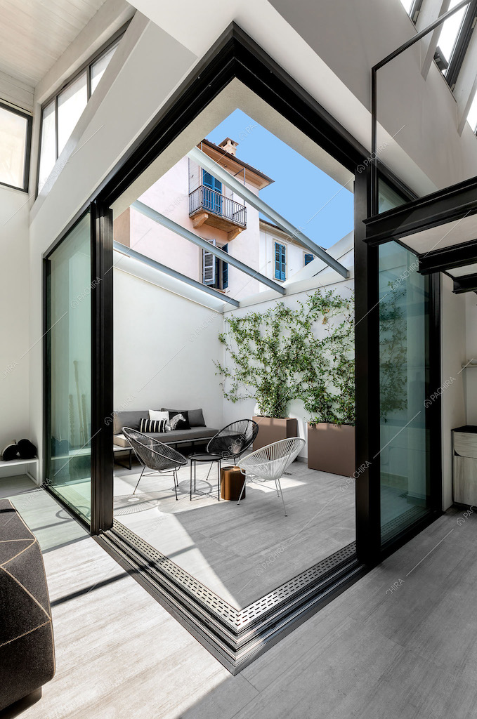 Giardino d'inverno dalle ampie vetrate con pavimento in parquet illumina tutto il loft