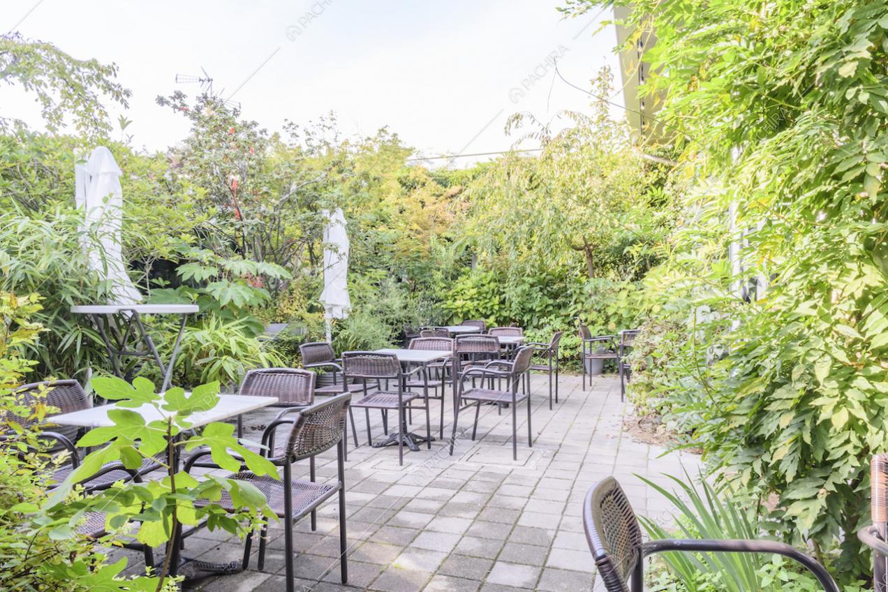 Giardino con tavoli e sedie da esterni e ombrelloni bianchi