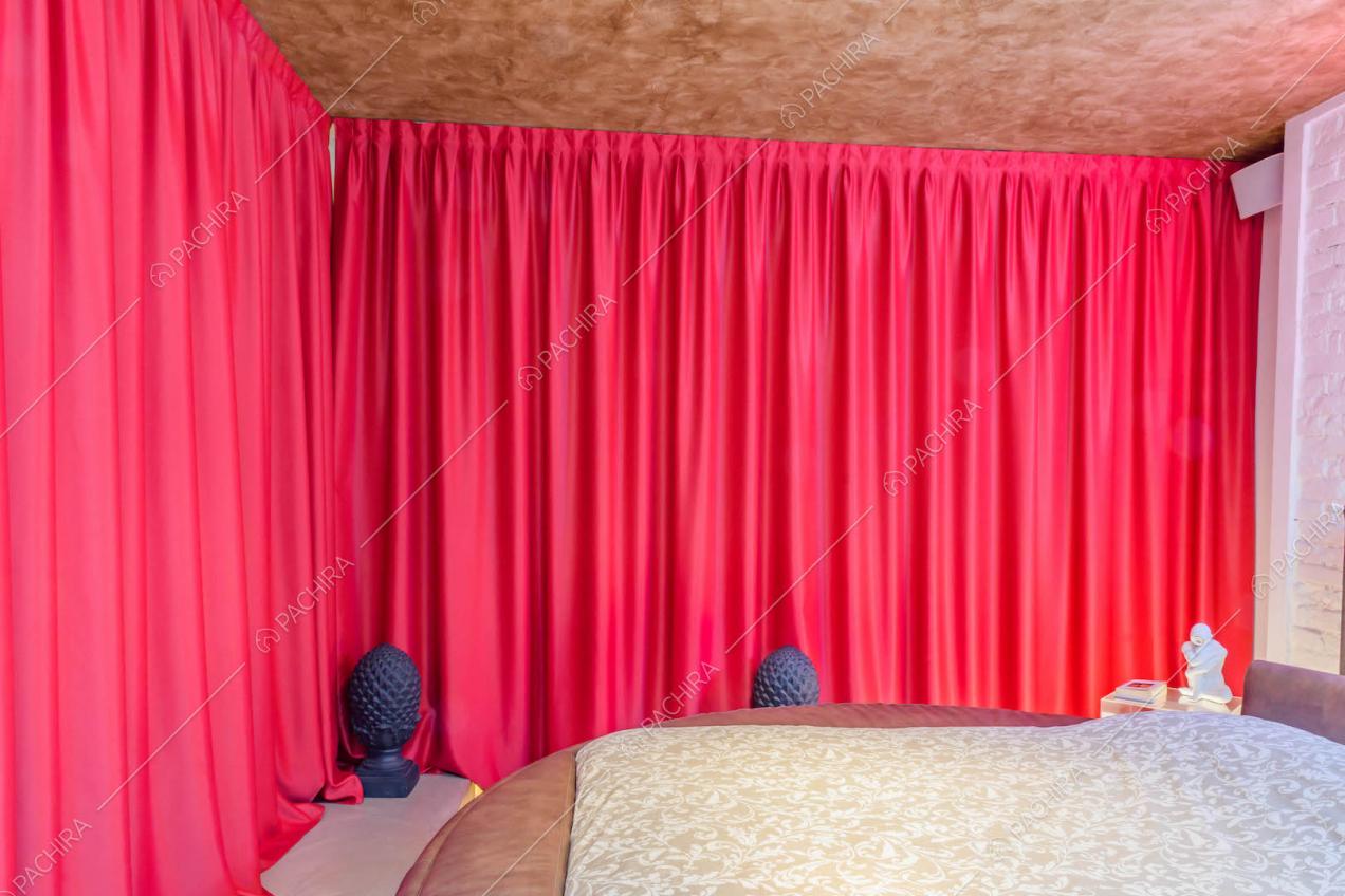 Tenda scorrevole fucsia nella camera con letto matrimoniale e parete in mattoni bianchi a vista