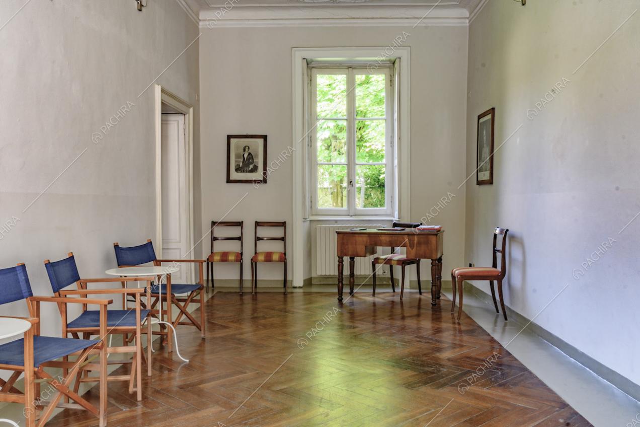 Stanza con pavimento in parquet a spina di pesce, pareti bianche e boiserie