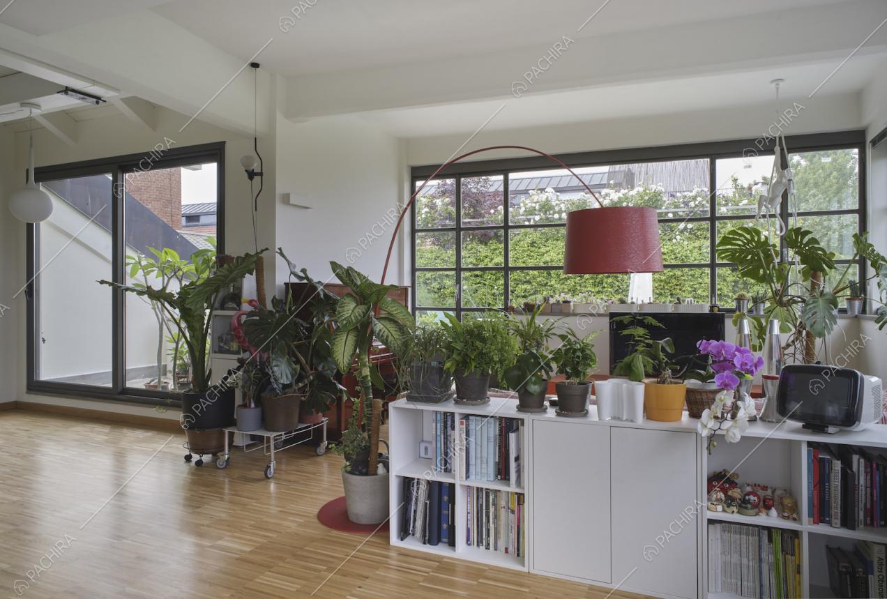 Ampia sala con mobile bianco, porta-finestra per accedere alla terrazza e pavimento in parquet