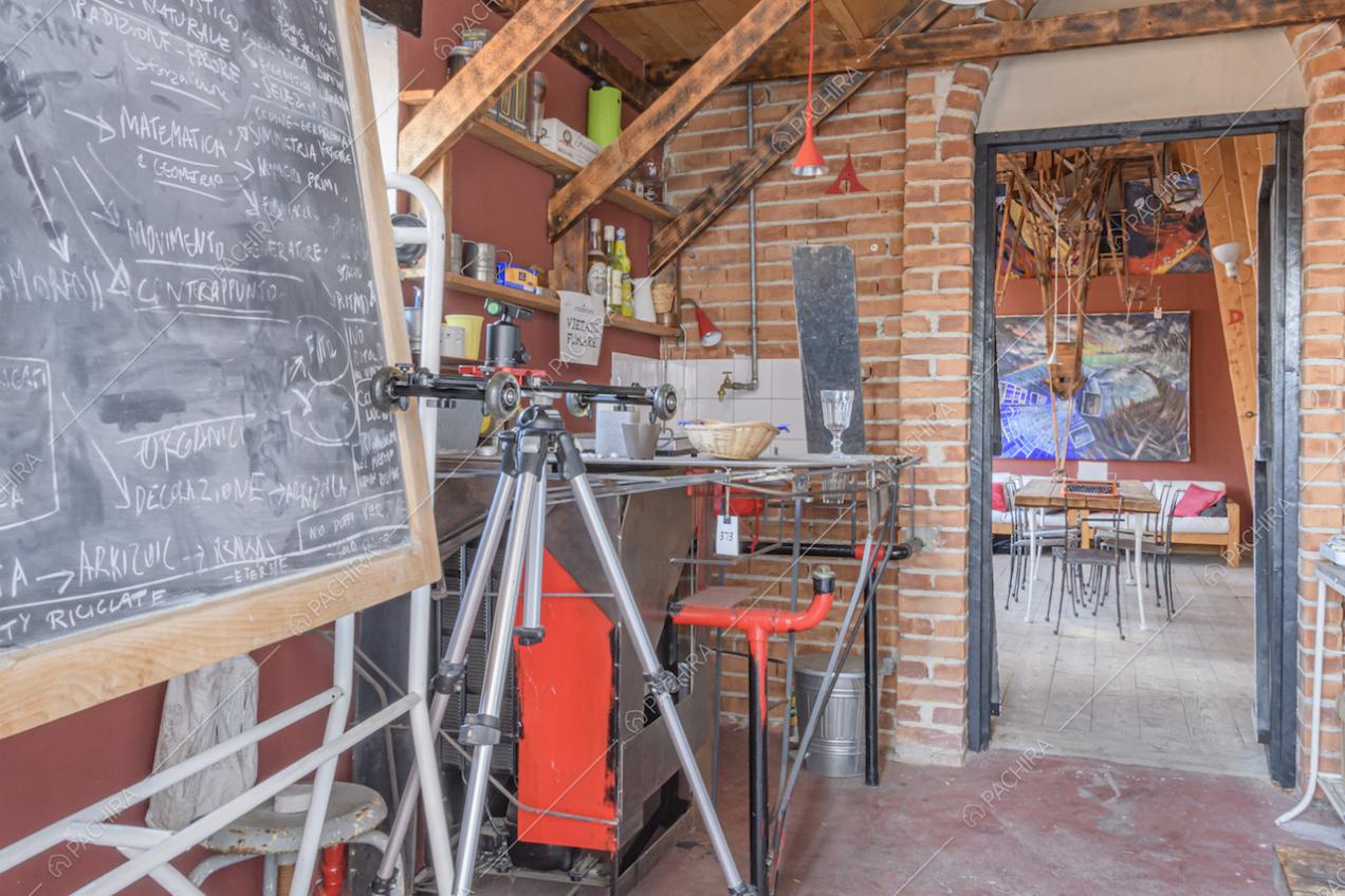 Parete in mattoni a vista, mensole in legno e lavagna