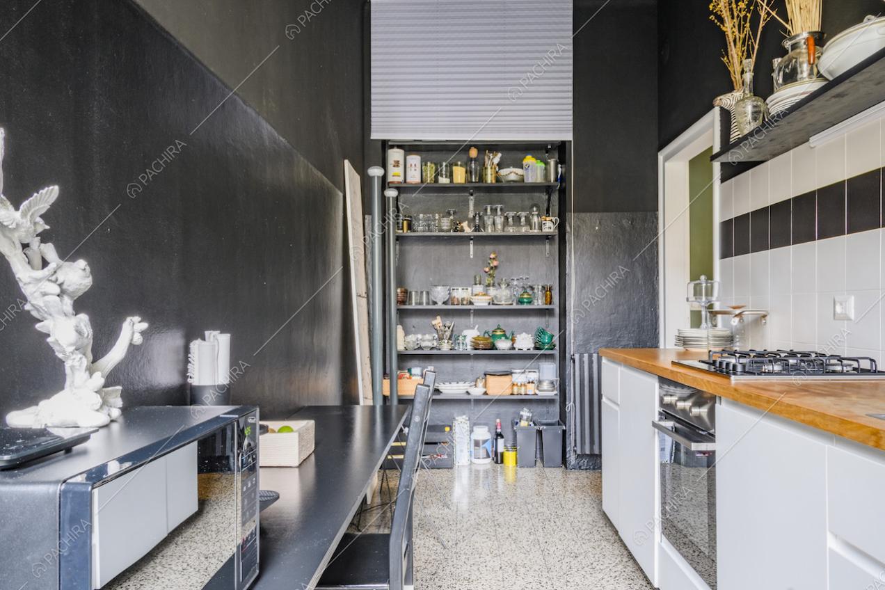 Scaffale con mensole e pareti nere nella cucina